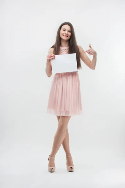 Woman in pink dress pointing on place copy — Stock Photo, Image