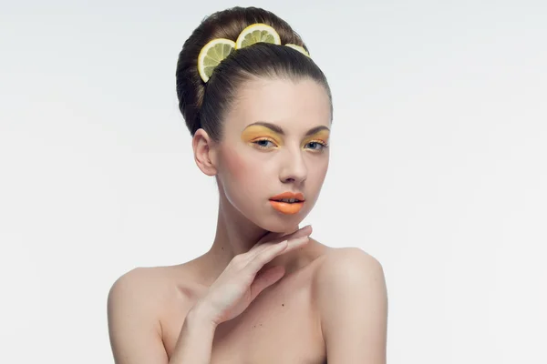 Mladá žena s pomeranče a make-up — Stock fotografie