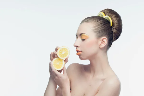 Jovem com laranjas e maquiagem — Fotografia de Stock