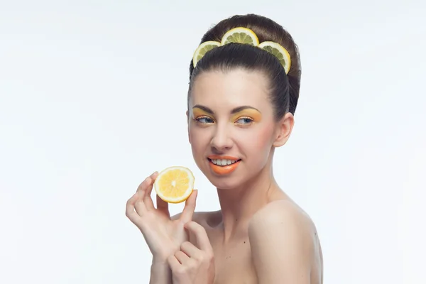 Mladá žena s pomeranče a make-up — Stock fotografie