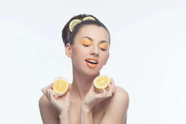 Mujer joven con naranjas y maquillaje — Foto de Stock