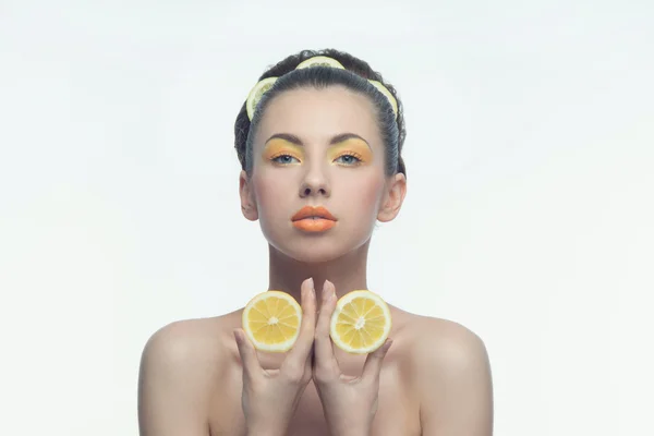 Jeune femme aux oranges et maquillage — Photo