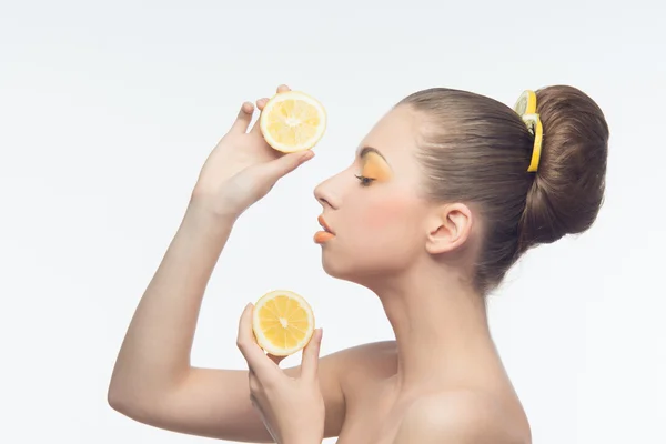 Mujer joven con naranjas y maquillaje — Foto de Stock