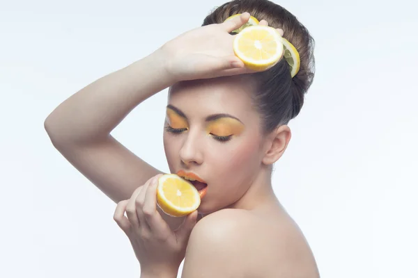 Jeune femme aux oranges et maquillage — Photo