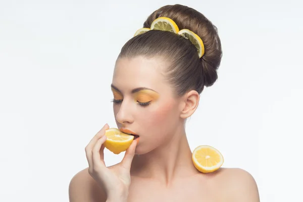 Jeune femme aux oranges et maquillage — Photo