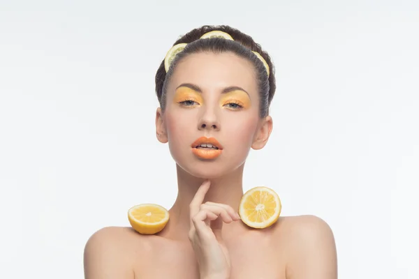 Mujer joven con naranjas y maquillaje — Foto de Stock