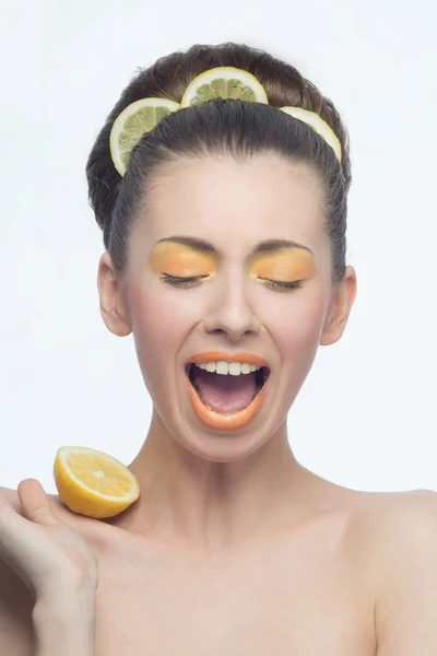 Jeune femme aux oranges et maquillage — Photo