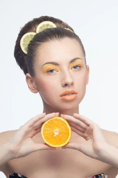 Jeune femme aux oranges et maquillage — Photo