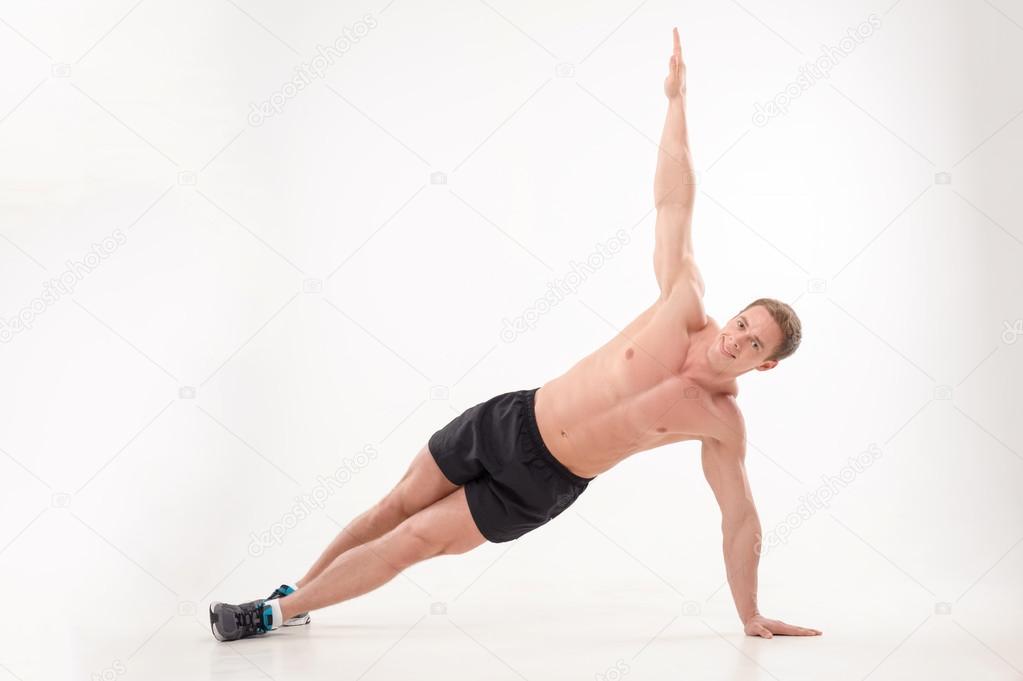 Man athlete doing fitness yoga exercises