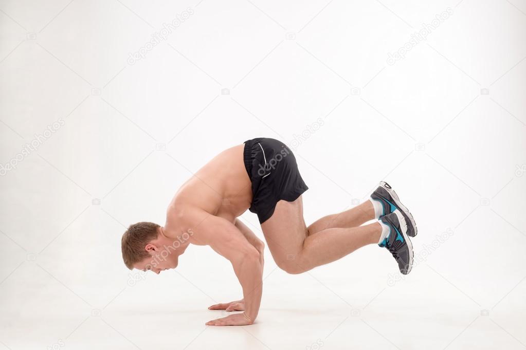 Man athlete doing fitness yoga exercises