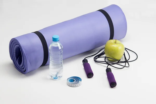 Yoga mat ile atlama ipi, elma, teyp ölçme ve su — Stok fotoğraf