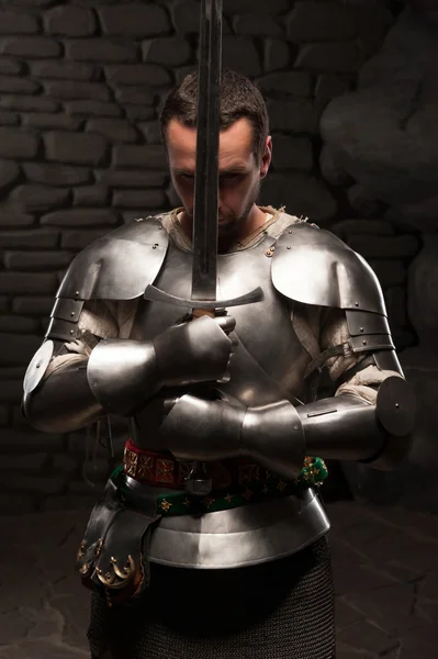 Medieval knight kneeling with sword — Stock Photo, Image