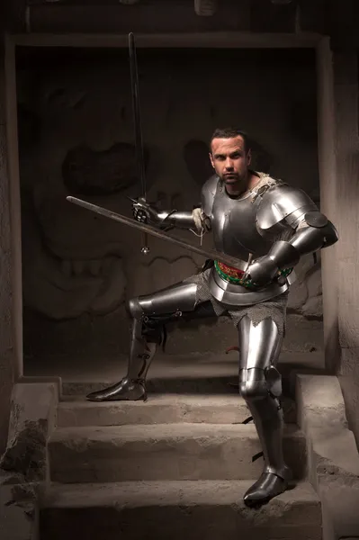 Medieval warrior posing on steps of ancient temple — Stock Photo, Image