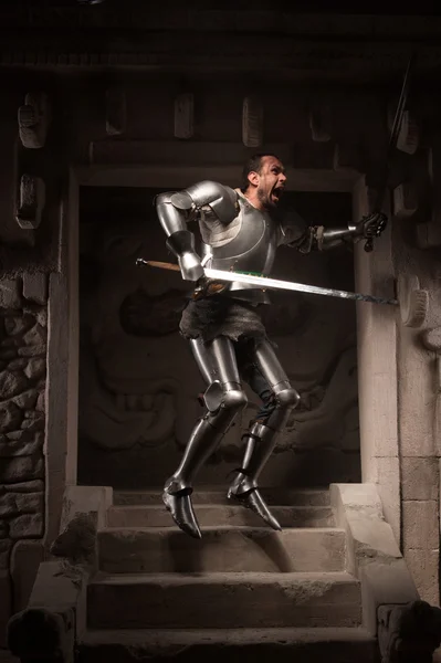 Medieval warrior posing on steps of ancient temple — Stock Photo, Image