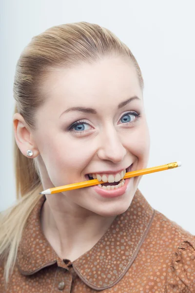 Aufgeregt attraktive Frau beißt Bleistift — Stockfoto