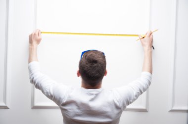 genç yakışıklı bir işçi ölçme bant ile