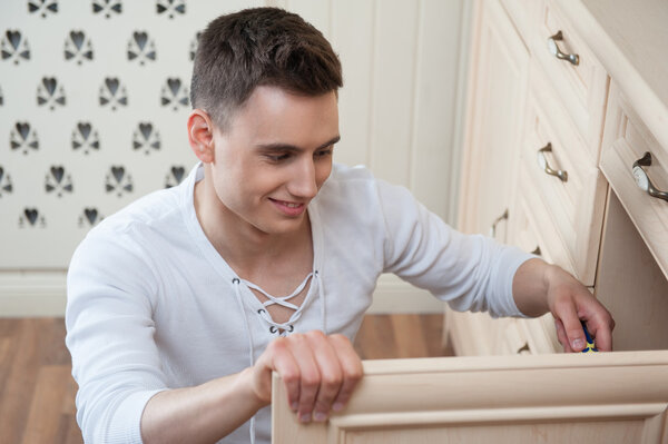 Young man assembling furniture