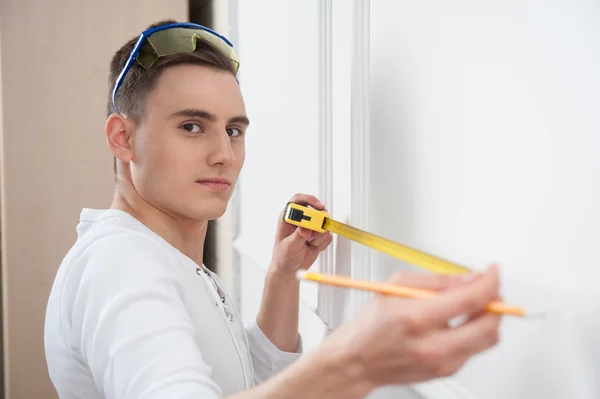 Joven trabajador guapo con cinta métrica —  Fotos de Stock