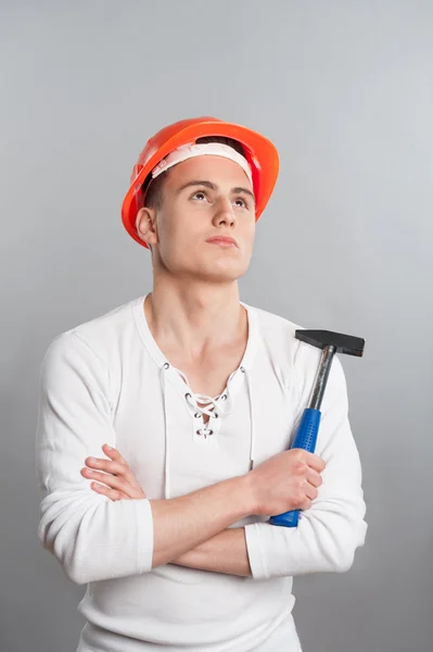 Pracovník v helmě drží kladivo — Stock fotografie