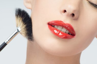 güzel bir genç kadın makyaj fırça uygulamak