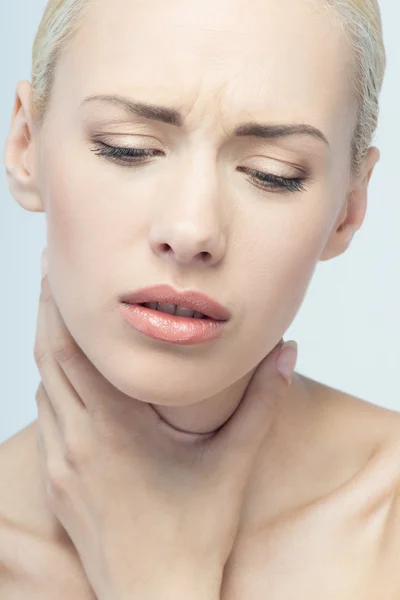 Pain concept. Young woman with touching her throat and head — Stock Photo, Image