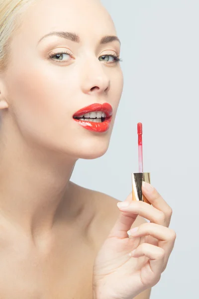 Beautiful woman applying lip gloss — Stock Photo, Image