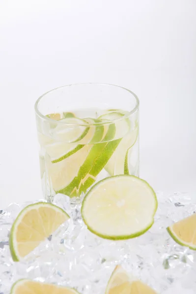 Glas van drank met ijsblokjes en vruchten op witte — Stockfoto