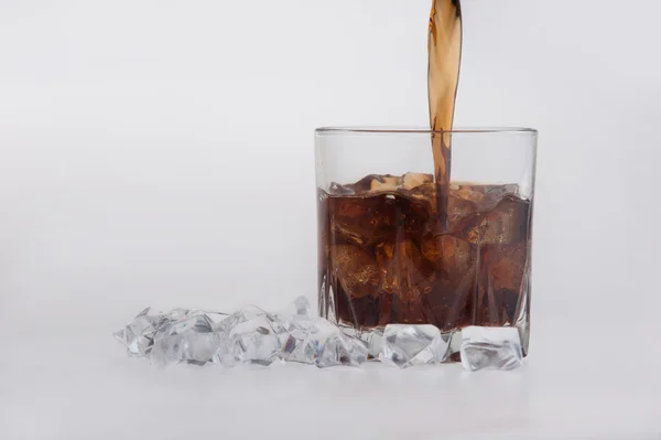 Tumbler of glowing golden brandy and ice — Stock Photo, Image