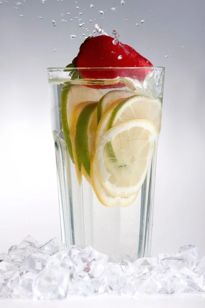 Glas van drank met ijsblokjes en vruchten — Stockfoto