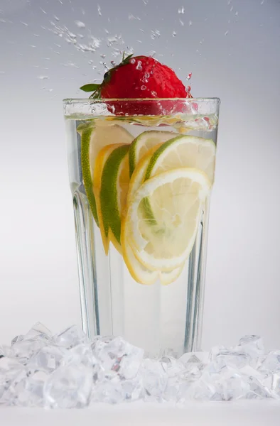 Glas van drank met ijsblokjes en vruchten — Stockfoto