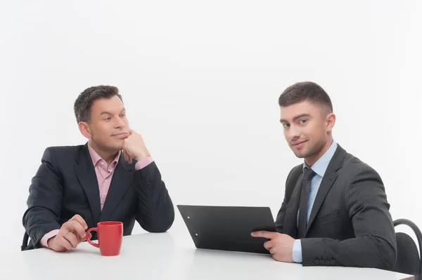 Geschäftsleute sitzen mit roter Tasse und Klemmbrett am Schreibtisch — Stockfoto