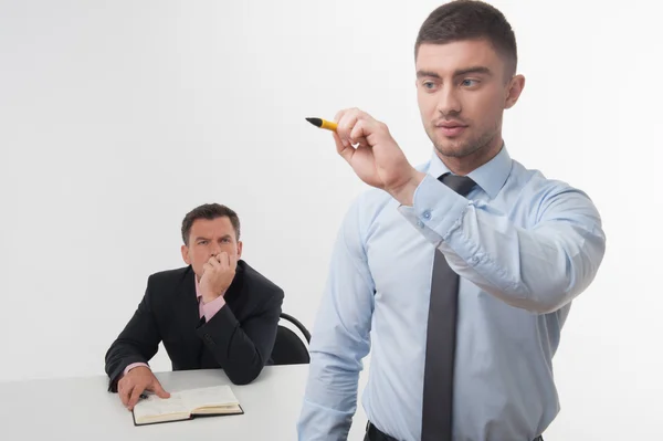 Businessman holds marker writing with his skeptical chief — Stock Photo, Image