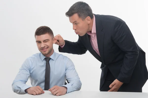 Seniorchef zieht Mitarbeiter am Ohr — Stockfoto