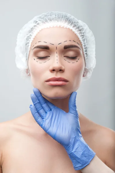 Hermosa mujer joven en gorra quirúrgica con líneas de perforación en — Foto de Stock