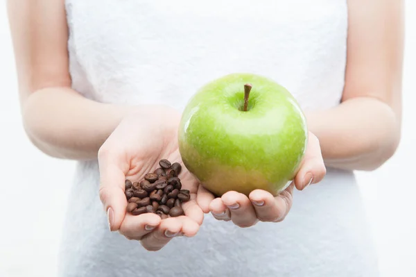 Vrouw met koffie bonen en groene appel — Stockfoto