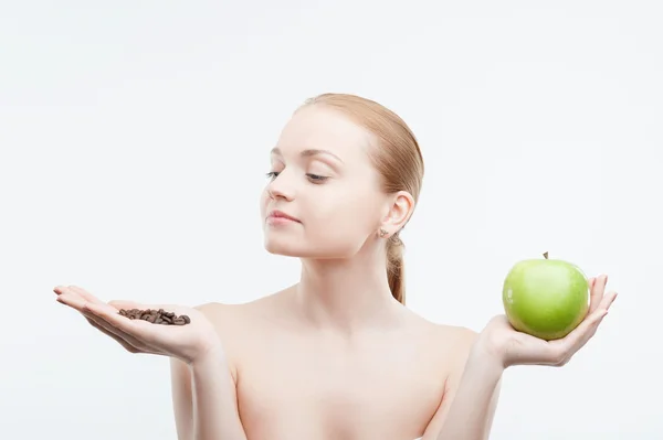 Женщина держит кофейные зерна и зеленое яблоко — стоковое фото