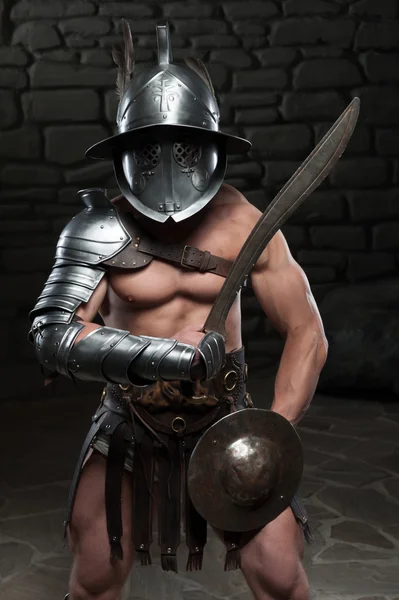 Gladiator w kasku i zbroja trzyma miecz — Zdjęcie stockowe