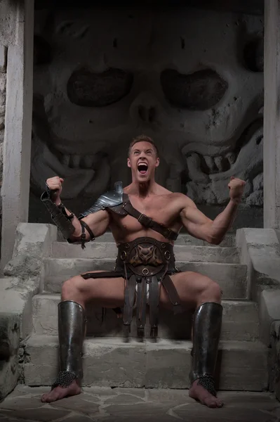 Gladiator in pantser zittend op de stappen van de oude tempel — Stockfoto