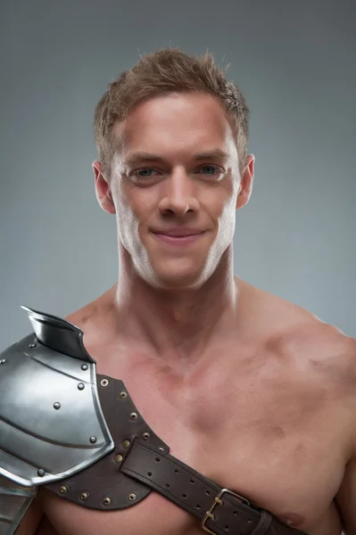 Nahaufnahme Porträt eines Gladiators in Rüstung vor grauem Hintergrund — Stockfoto
