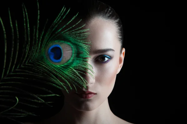 Beautiful brunette young woman with peacock style make-up and pe — Stock Photo, Image