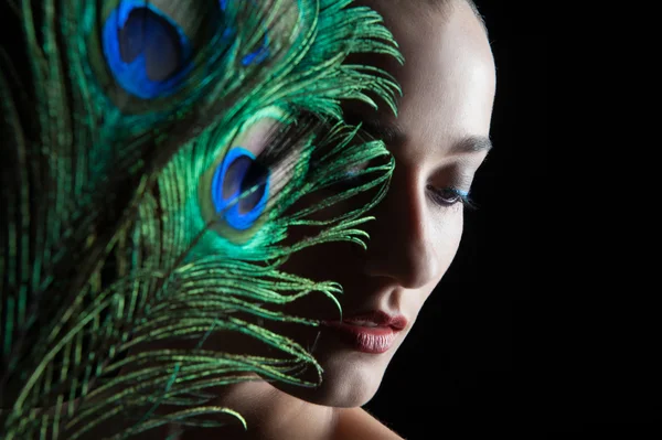 Beautiful brunette young woman with peacock style make-up and pe — Stock Photo, Image