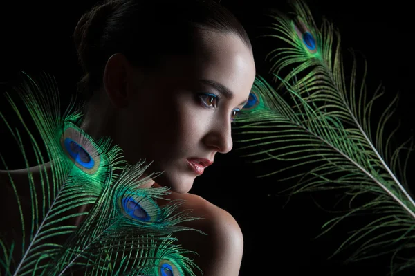 Beautiful brunette young woman with peacock style make-up and pe — Stock Photo, Image