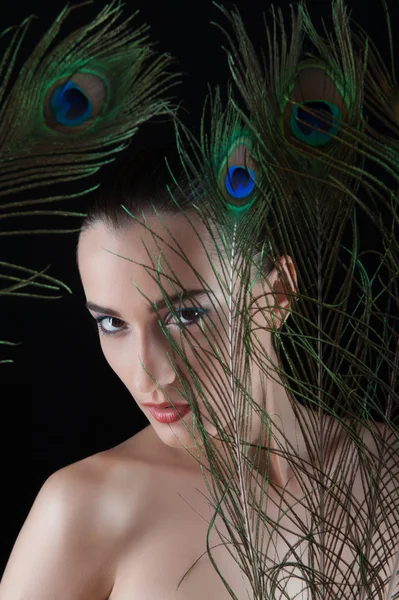 Beautiful brunette young woman with peacock style make-up and pe — Stock Photo, Image