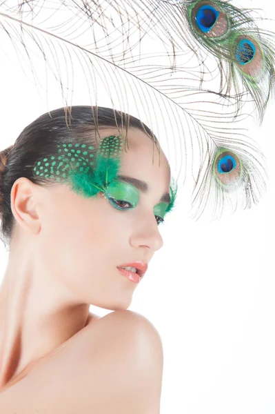 Beautiful brunette young woman with peacock style make-up and pe — Stock Photo, Image