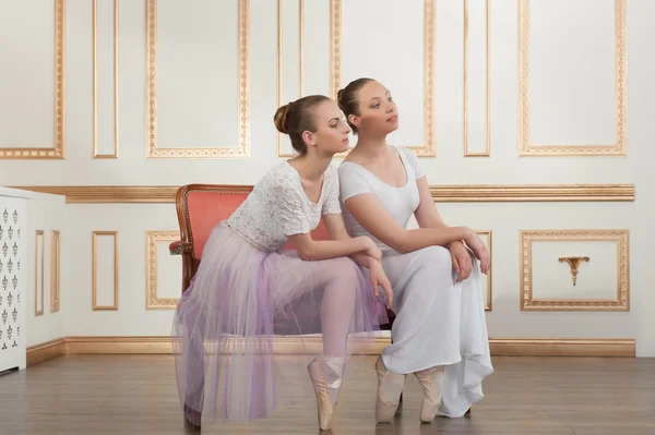 Zwei junge schöne Balletttänzerinnen sitzen auf einem Sofa in klassischer — Stockfoto