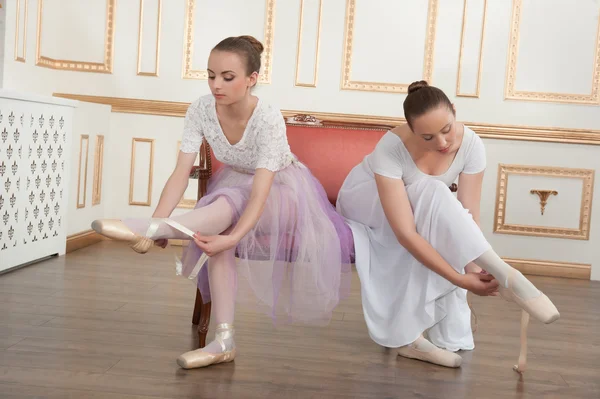 Zwei junge schöne Balletttänzerinnen sitzen auf einem Sofa in klassischer — Stockfoto
