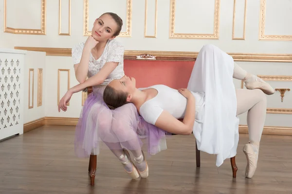 Dvě mladé krásné baletky sedí na pohovce v klasické — Stock fotografie