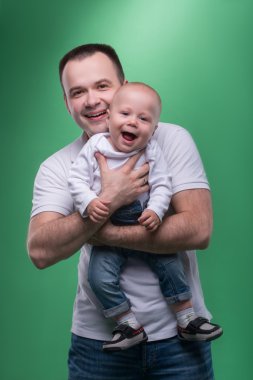 Onun bebek çocuk kucaklayan mutlu gülümseyen baba