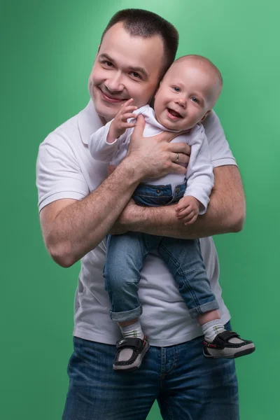 Счастливый улыбающийся отец обнимает своего малыша — стоковое фото