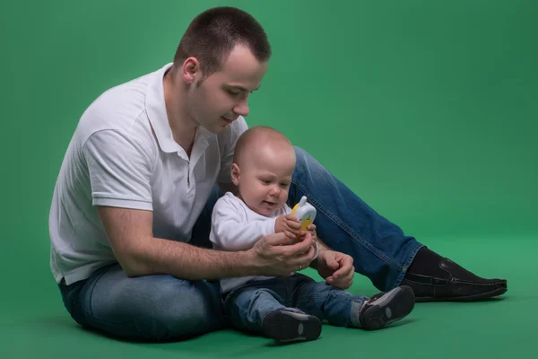 Père et fils tout-petit jouant avec un téléphone portable jouet — Photo